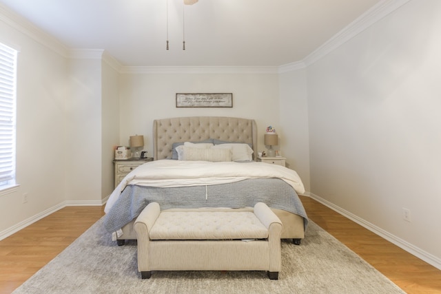 bedroom featuring multiple windows, crown molding, and hardwood / wood-style flooring