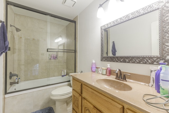 full bathroom with combined bath / shower with glass door, vanity, and toilet