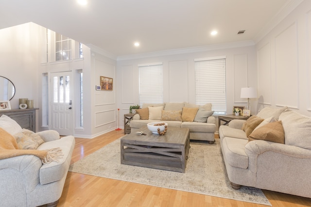 living room featuring light hardwood / wood-style floors and ornamental molding