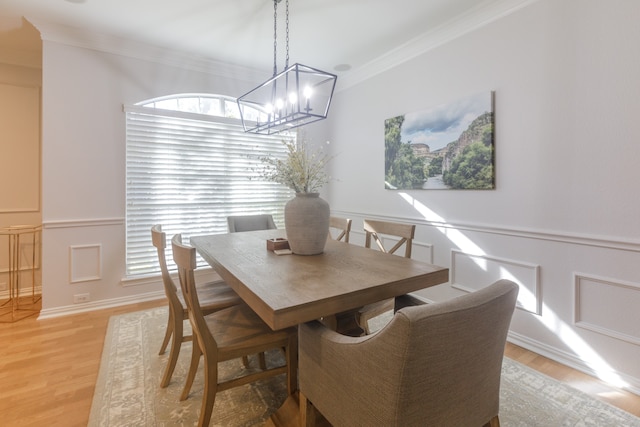 dining room with a wealth of natural light, crown molding, a notable chandelier, and light wood-type flooring