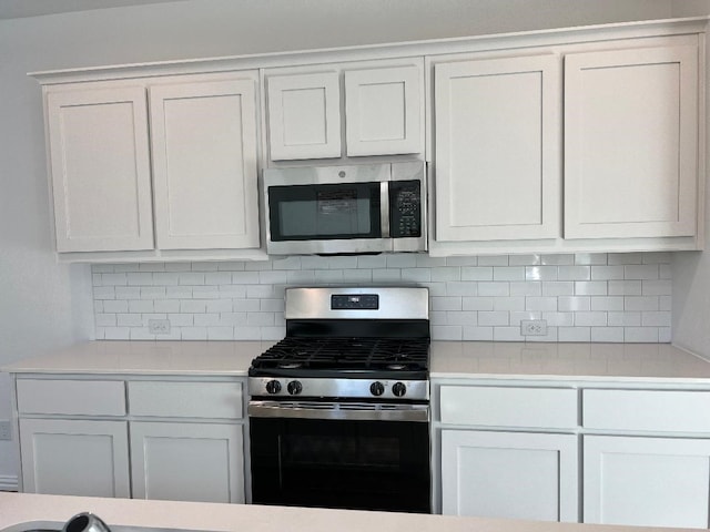 kitchen featuring white cabinets, decorative backsplash, and stainless steel appliances