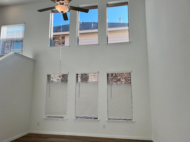 unfurnished room featuring ceiling fan and dark wood-type flooring