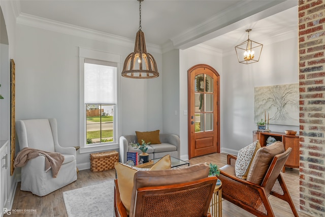 sitting room featuring a chandelier, crown molding, and light hardwood / wood-style flooring