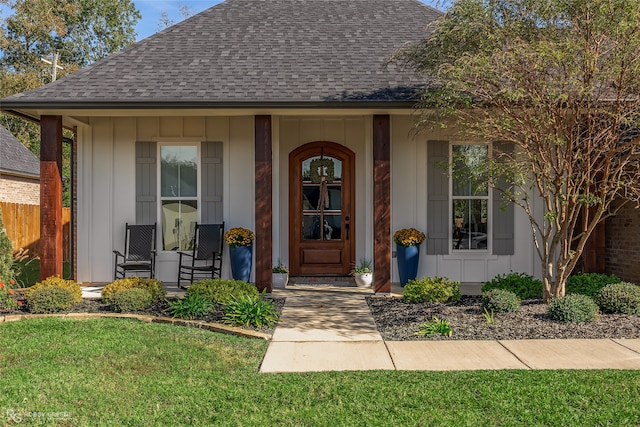 entrance to property with a lawn and a porch