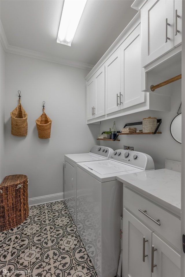 washroom with cabinets, ornamental molding, and washing machine and clothes dryer