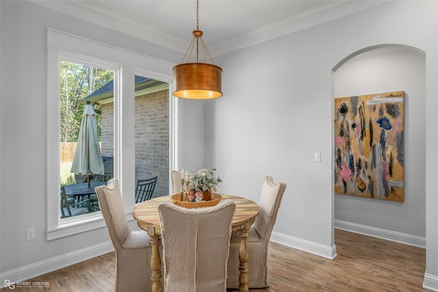 dining room featuring wood-type flooring and crown molding