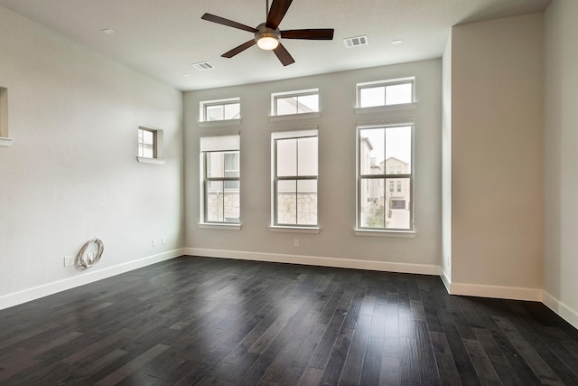 spare room featuring plenty of natural light, dark hardwood / wood-style floors, and ceiling fan