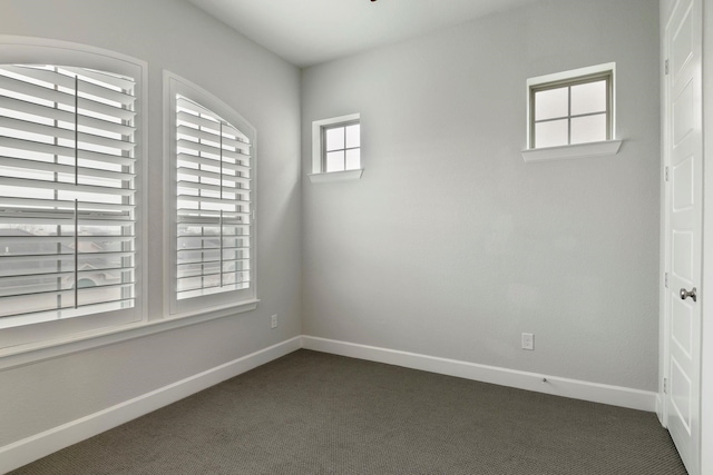 spare room featuring dark carpet