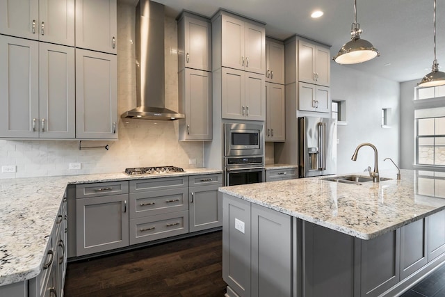 kitchen featuring gray cabinetry, sink, wall chimney range hood, and appliances with stainless steel finishes