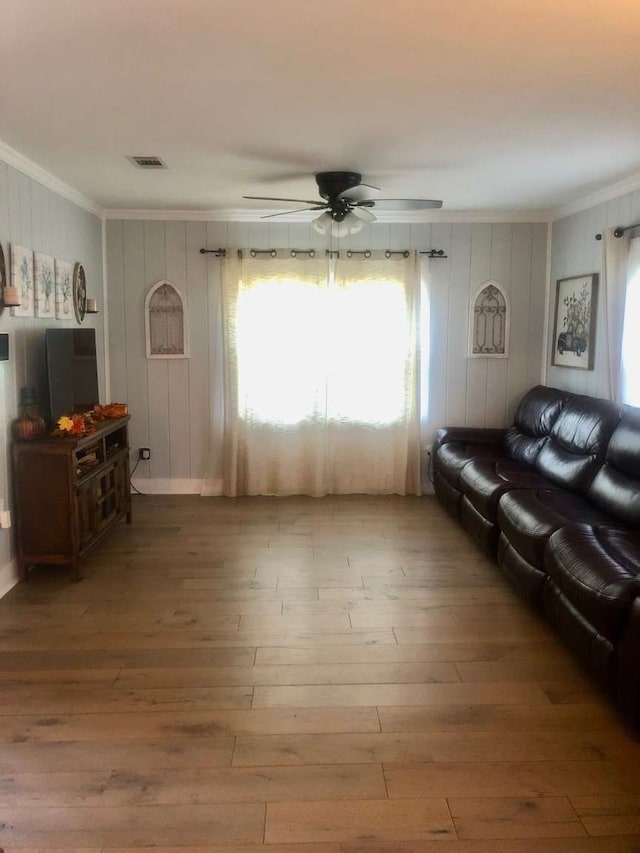 living room featuring hardwood / wood-style floors, ceiling fan, and ornamental molding