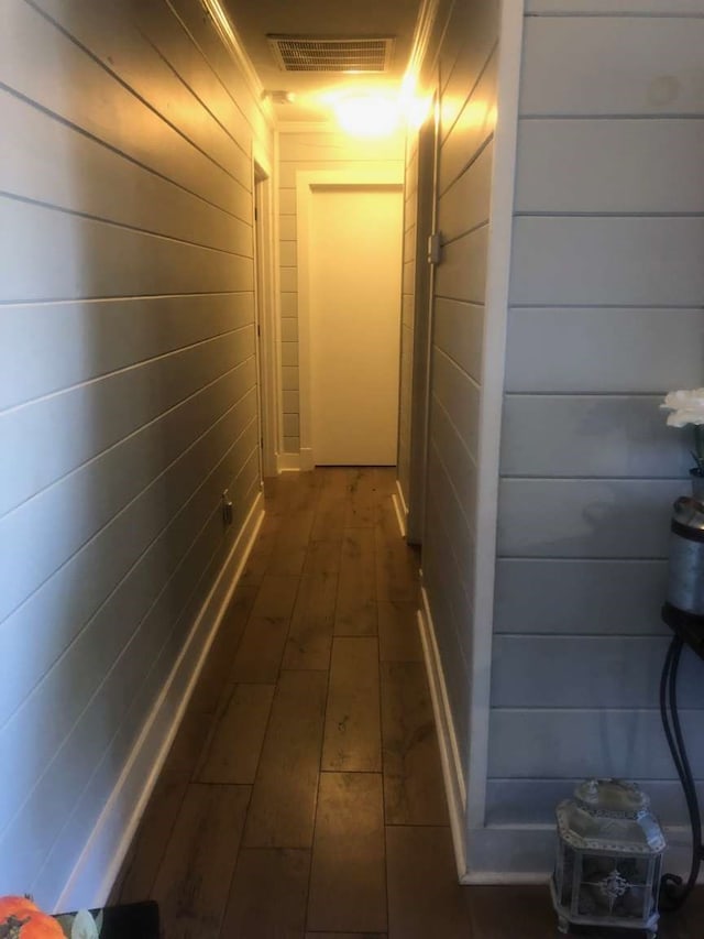 hall featuring dark hardwood / wood-style flooring and wooden walls