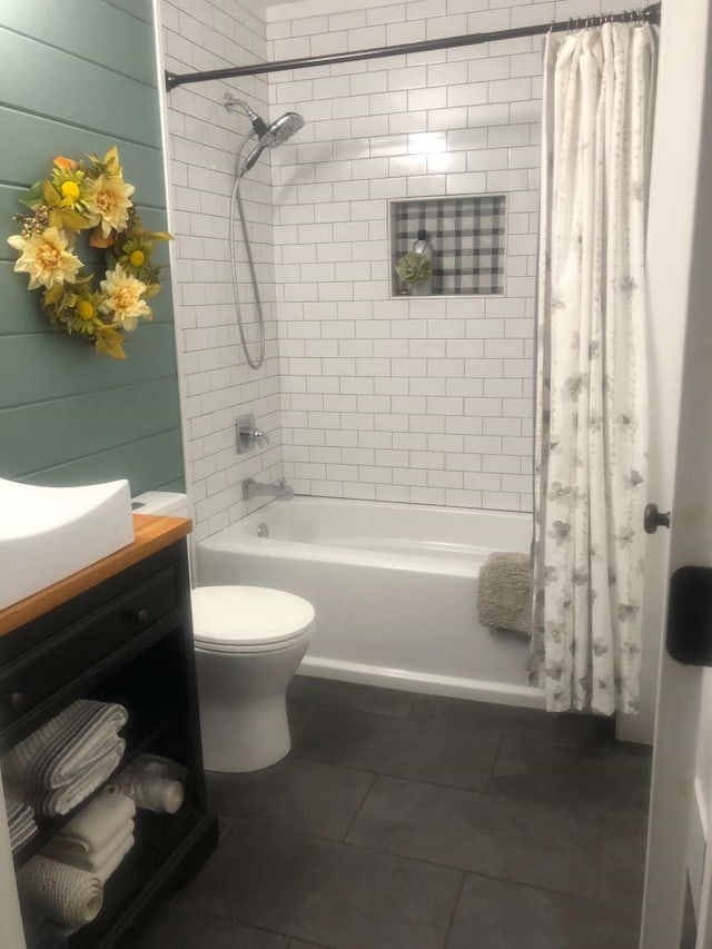 full bathroom with wooden walls, vanity, shower / bath combo, and toilet