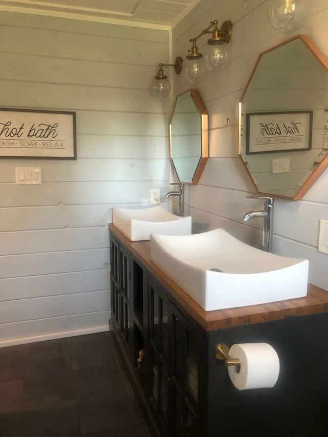 bathroom with vanity and wooden walls