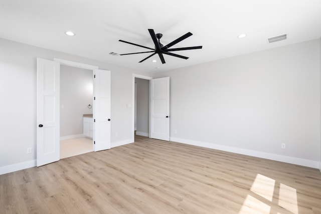 unfurnished bedroom featuring light wood-type flooring, ceiling fan, and connected bathroom