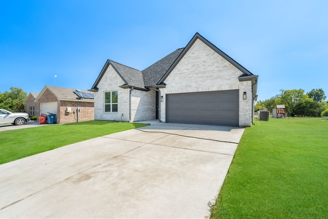 french country style house featuring cooling unit, a front yard, and a garage