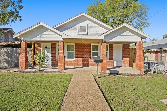 view of front of house with a front yard and a porch