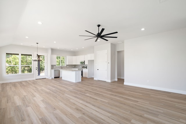 kitchen with pendant lighting, a center island, appliances with stainless steel finishes, light hardwood / wood-style floors, and white cabinetry