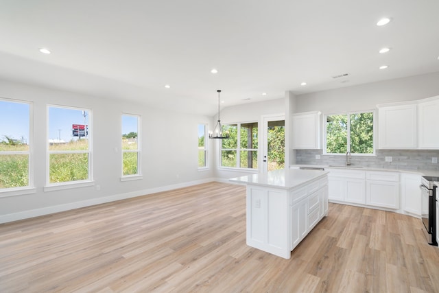 kitchen featuring an inviting chandelier, light hardwood / wood-style flooring, white cabinetry, and a kitchen island