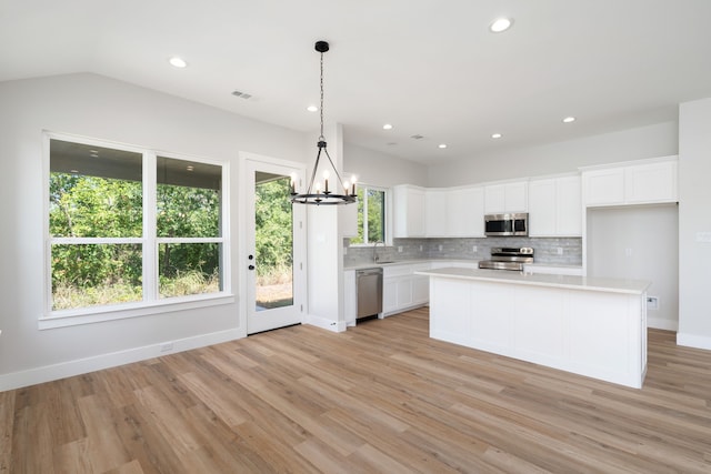 kitchen featuring a kitchen island, white cabinets, stainless steel appliances, and light wood-type flooring