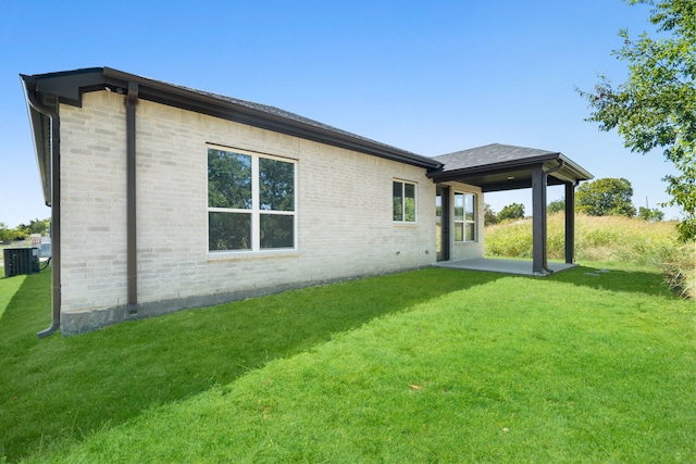 back of house featuring central AC, a patio area, and a yard