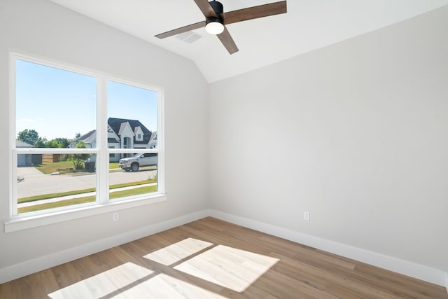 spare room with ceiling fan, lofted ceiling, and light wood-type flooring