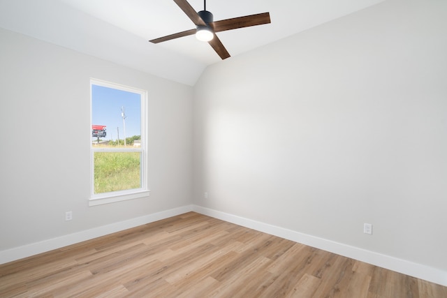 empty room with ceiling fan, light hardwood / wood-style flooring, and vaulted ceiling