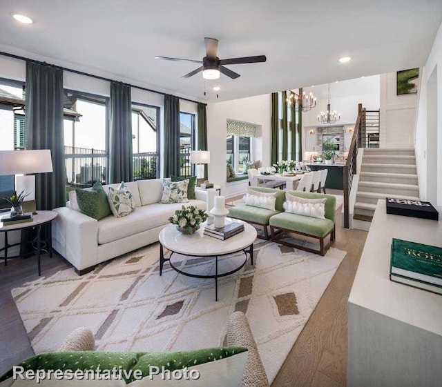 living room with a wealth of natural light and ceiling fan with notable chandelier