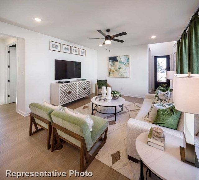 living room featuring ceiling fan and wood-type flooring