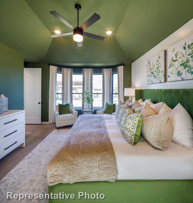 bedroom with hardwood / wood-style flooring, ceiling fan, and lofted ceiling