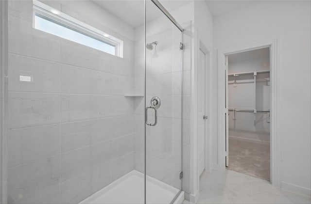 4182 Carter Ct, Denison, TX 75020 - bathroom featuring a shower stall, a spacious closet, and marble look tile flooring