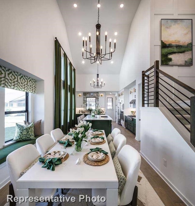 dining space featuring dark hardwood / wood-style flooring, an inviting chandelier, and high vaulted ceiling