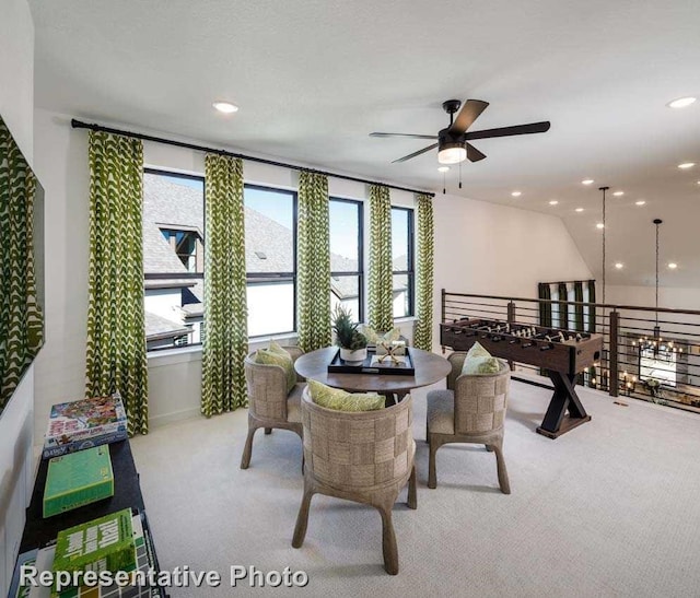 carpeted dining area with ceiling fan