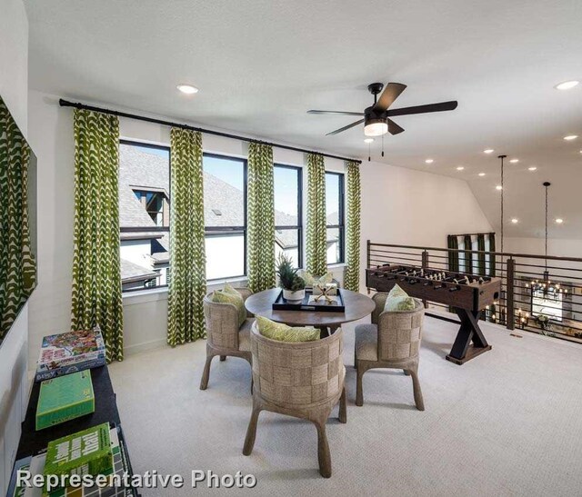 carpeted dining area with ceiling fan