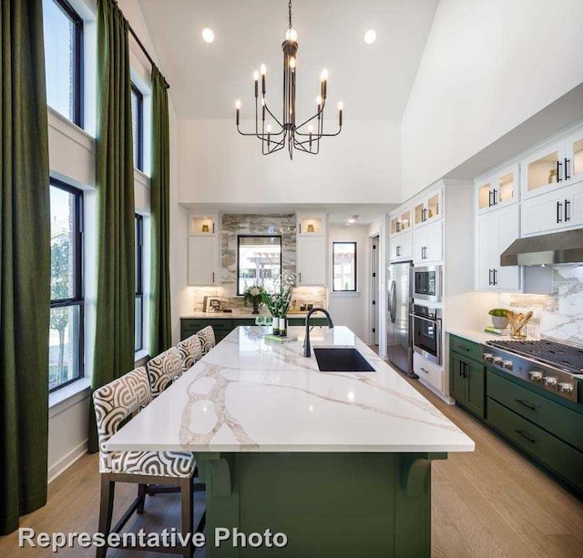 kitchen with stainless steel appliances, a spacious island, sink, white cabinets, and hanging light fixtures