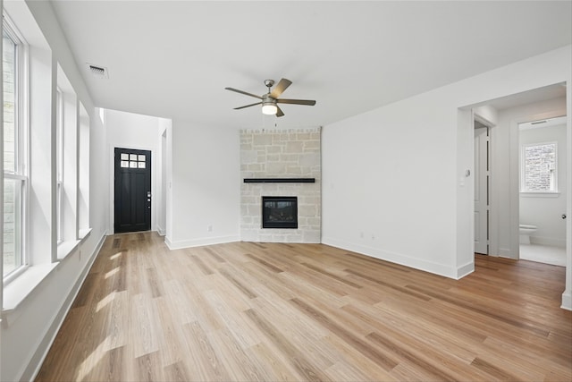 4182 Carter Ct, Denison, TX 75020 - unfurnished living room featuring ceiling fan, light wood-style flooring, a stone fireplace, and baseboards