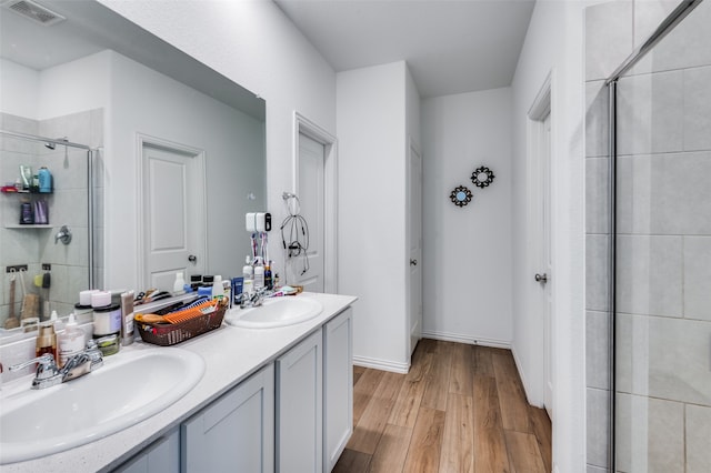 bathroom with vanity, an enclosed shower, and wood-type flooring