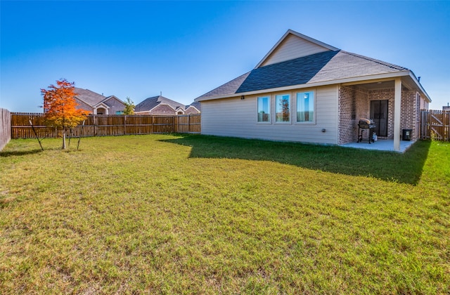 back of house featuring a lawn and a patio