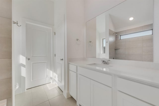 bathroom with tile patterned flooring, vanity, and tiled shower