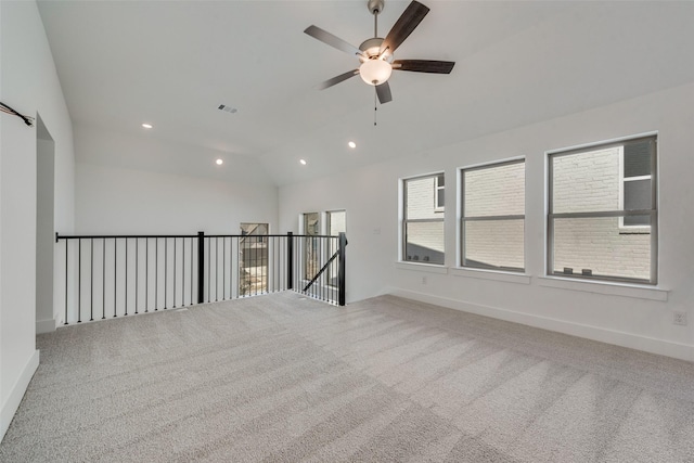 spare room featuring lofted ceiling, ceiling fan, and carpet flooring