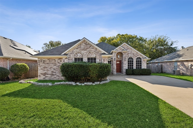 ranch-style house with a front lawn and central air condition unit