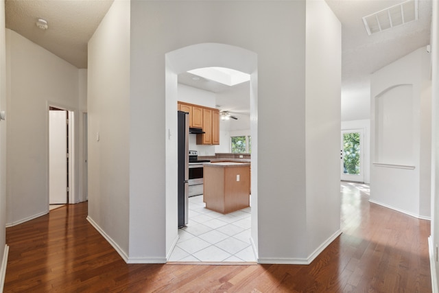 hall with light hardwood / wood-style flooring and a textured ceiling