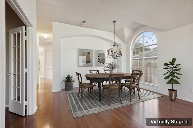 dining room with dark hardwood / wood-style flooring, a chandelier, and a textured ceiling