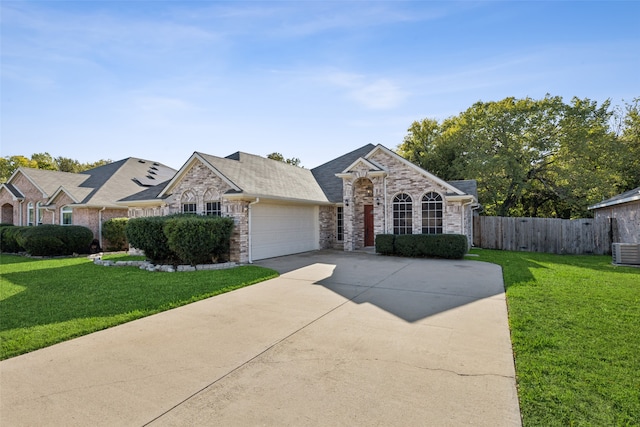 single story home featuring cooling unit, a garage, and a front lawn