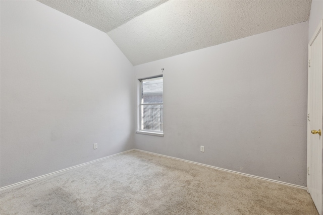 carpeted empty room featuring a textured ceiling and lofted ceiling