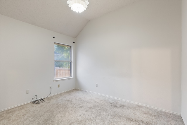 unfurnished room featuring light colored carpet and vaulted ceiling