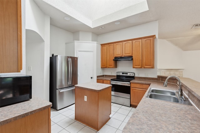 kitchen with sink, a kitchen island, stainless steel appliances, and light tile patterned floors