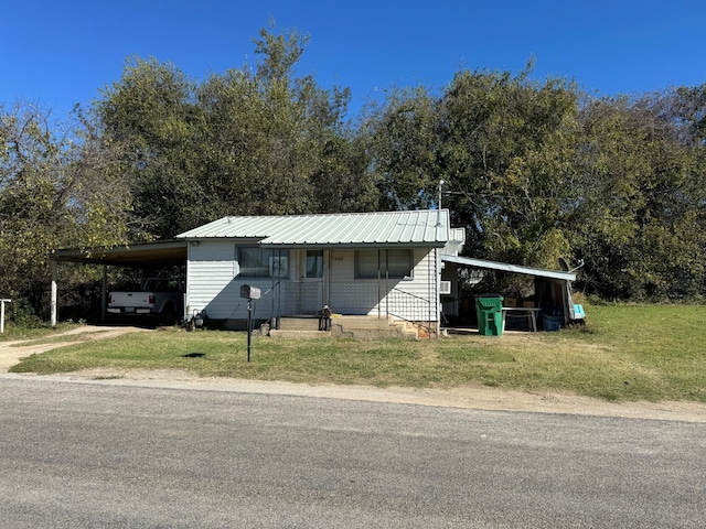 view of front facade with a front yard and a carport