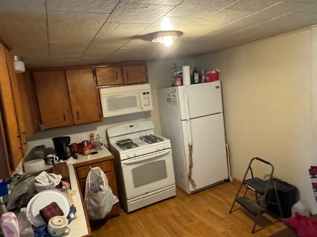 kitchen with white appliances and light hardwood / wood-style flooring