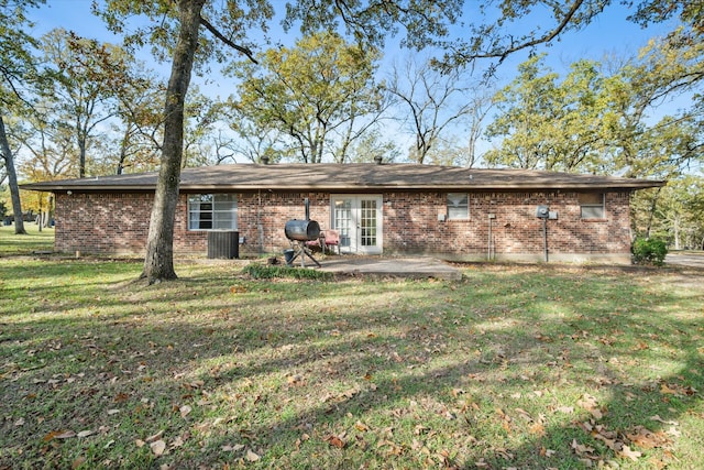 back of property with a lawn, a patio area, and cooling unit