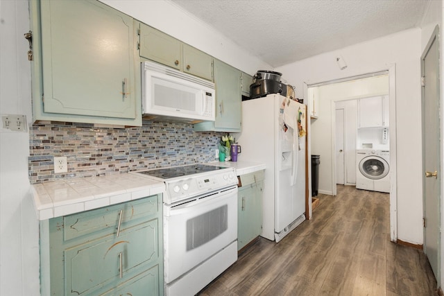 kitchen featuring white appliances, a textured ceiling, tile counters, dark hardwood / wood-style flooring, and washer / dryer